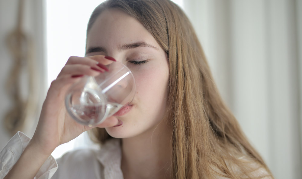 female drinking glass of water